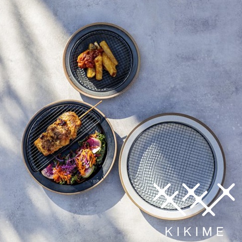 美濃燒瀝油餐盤，黑色盤體搭配半月形黑色濾網，上方盛有炸物與醬汁。另一盤為黑色盤體，盛有烤肉串與沙拉。右側為白色盤體，僅有黑色濾網。