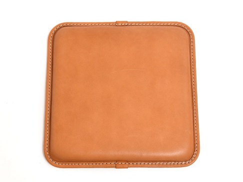職人手作皮革方形坐墊，淺棕色皮革，細緻的白色縫線，邊緣圓潤。