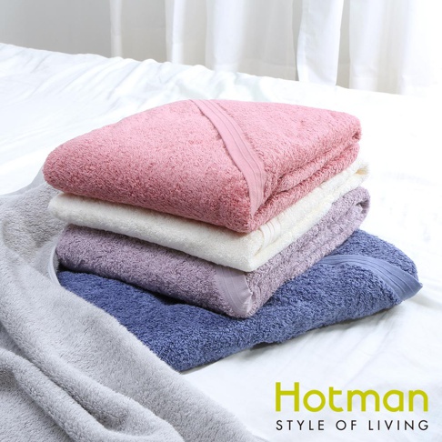 堆疊的五條毛巾，由上至下顏色分別為：粉紅色、白色、淡紫色、藍紫色，以及一條置於左側的淺灰色毛巾。毛巾質地柔軟，表面有絨毛感。