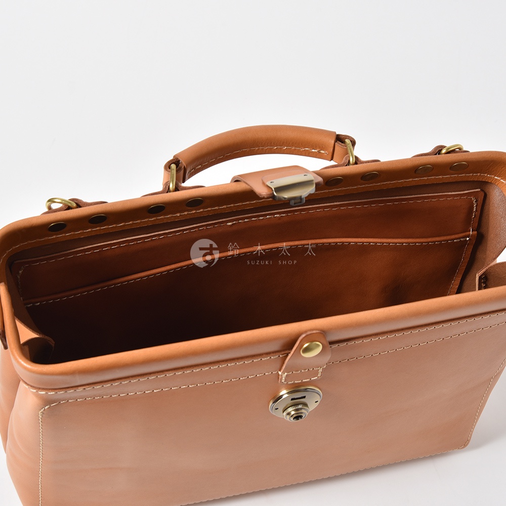 職人手作皮革軟式杜勒斯三用背包 BJ-16，展示為淺棕色皮革，設有經典金屬鎖扣、手提把及內部分層口袋，搭配白色縫線。