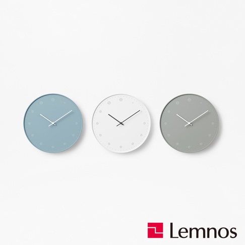 三款 Molecule 原子時鐘，分別為淺藍色、白色和灰色。時鐘皆為圓形，擁有簡約的白色指針，錶盤上有細小的裝飾圖案和刻度。