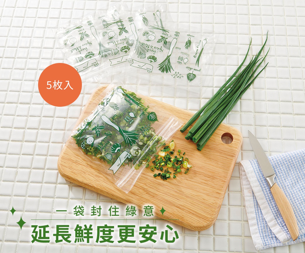 透明塑膠密封保鮮袋，印有綠色蔬菜圖案，內裝切碎的蔥段。一疊四個未開封的保鮮袋，以及一把木柄刀和一塊藍白格紋布。