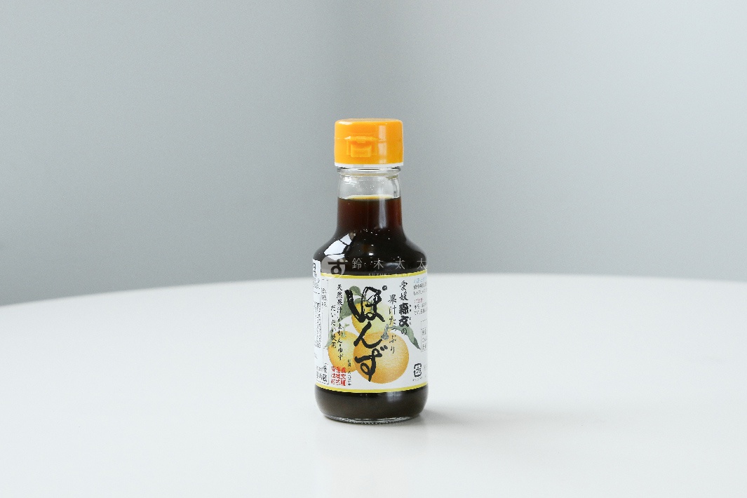 玻璃瓶裝森文柑橘醋調味料，醬色呈深褐色，瓶蓋為黃色。標籤上有日文說明文字及兩顆柑橘圖案，其中一顆為切開的黃色果肉。