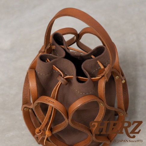 日本HERZ職人手作Organ編織水桶包 G-98，深棕色帆布內袋搭配皮革編織外框，有Made in JAPAN Since1973字樣。