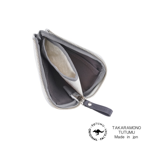 TUTUMU 品牌標誌與 TAKARAMONO TUTUMU Made in jpn 字樣旁，是打開的白色拉鍊小錢包，內部有灰色的內襯和一個米白色內袋。