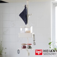 白色直撐架上掛有深藍色布料，架上層有兩個透明儲物盒，下方有白色收納籃，籃旁掛著金屬夾。下層有兩個玻璃罐，分別裝有紅色和綠色顆粒狀物品，架子底部有掛勾。