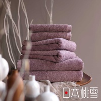 日本桃雪標誌旁堆疊著一疊紫粉色毛巾