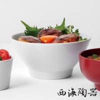 白色陶瓷料理丼碗，內盛有日式丼飯，碗中可見烤雞肉、生蛋黃和綠色蔬菜。右側為紅色陶瓷湯碗。