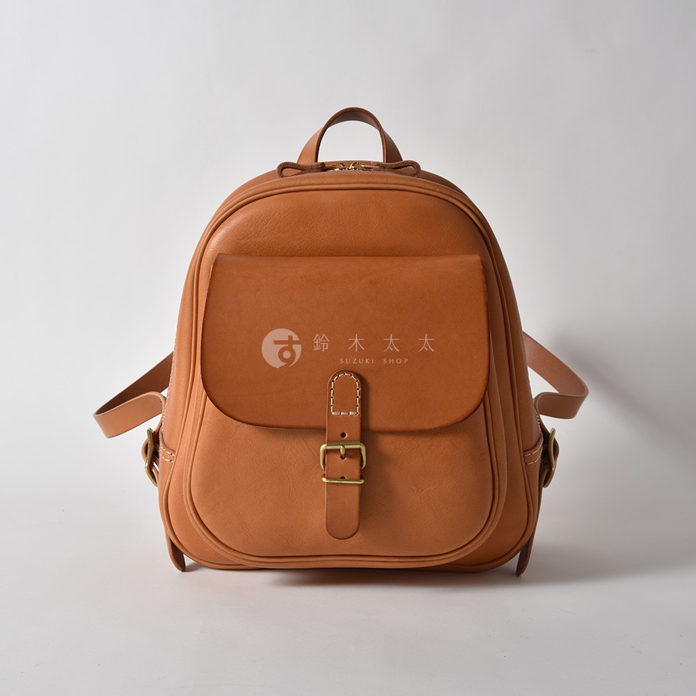 棕色皮革製成的迷你後背包，具有立體口袋和金屬扣環，適合日常使用。