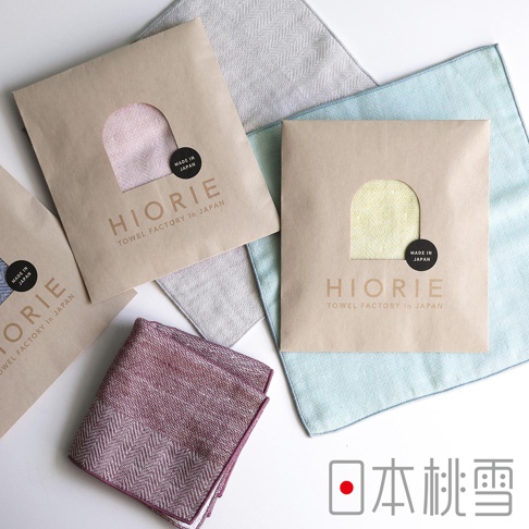 日本製 HIORIE 今治毛巾，以粉色、黃色和紅紫色人字紋毛巾組成的 quatrefoil 佈局，搭配日文「日本桃雪」文字。
