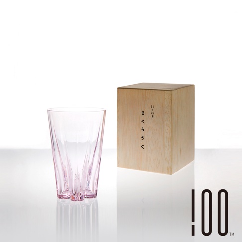 粉色玻璃水杯，杯身有垂直線條紋理，底部呈三足狀，置於木盒旁。