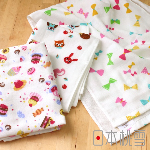 三條白色紗布毛巾，分別印有杯子蛋糕、糖果、動物（貓、兔子、貓頭鷹、刺蝟）圖案，以及彩色蝴蝶結圖案。材質為輕薄透氣的紗布。