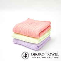 三層紗純棉寶寶裹身毯，堆疊展示，由上而下分別為珊瑚粉、淺綠與淡紫色，材質柔軟，紋理清晰。