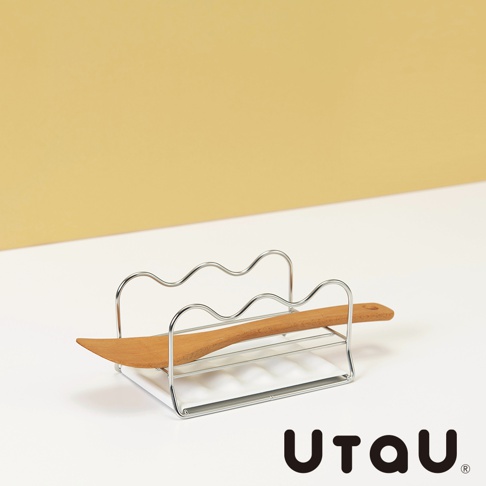 不鏽鋼多功能萬用瀝水支架，銀色，上方有波浪狀的支架，下方有條狀底座，支架上放置一支木製鍋鏟。