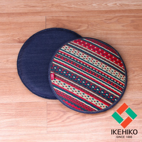兩張天然藺草紋織圓型坐墊，一張為深藍色牛仔布材質，另一張表面有紅、綠、米白、深棕色條紋及點狀圖案，邊緣皆以深藍色布包覆。