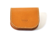 職人手作皮革馬蹄造型零錢包，採用天然皮革製成，顏色為溫潤的棕褐色，縫線細緻，正面壓印有「HERZ」品牌標誌及「MADE IN JAPAN」字樣，設計簡約實用。