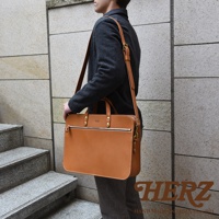 職人手作皮革兩用商務公事包，淺棕色皮革，配有頂部提把、可拆卸肩帶、前方拉鍊口袋及金屬配件。