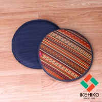 兩個天然藺草紋織圓型坐墊，其中一個表面有藍色牛仔布材質，另一個表面則為條紋藺草編織，顏色包含橘色、棕色、紫色和米色，邊緣以牛仔布包覆。