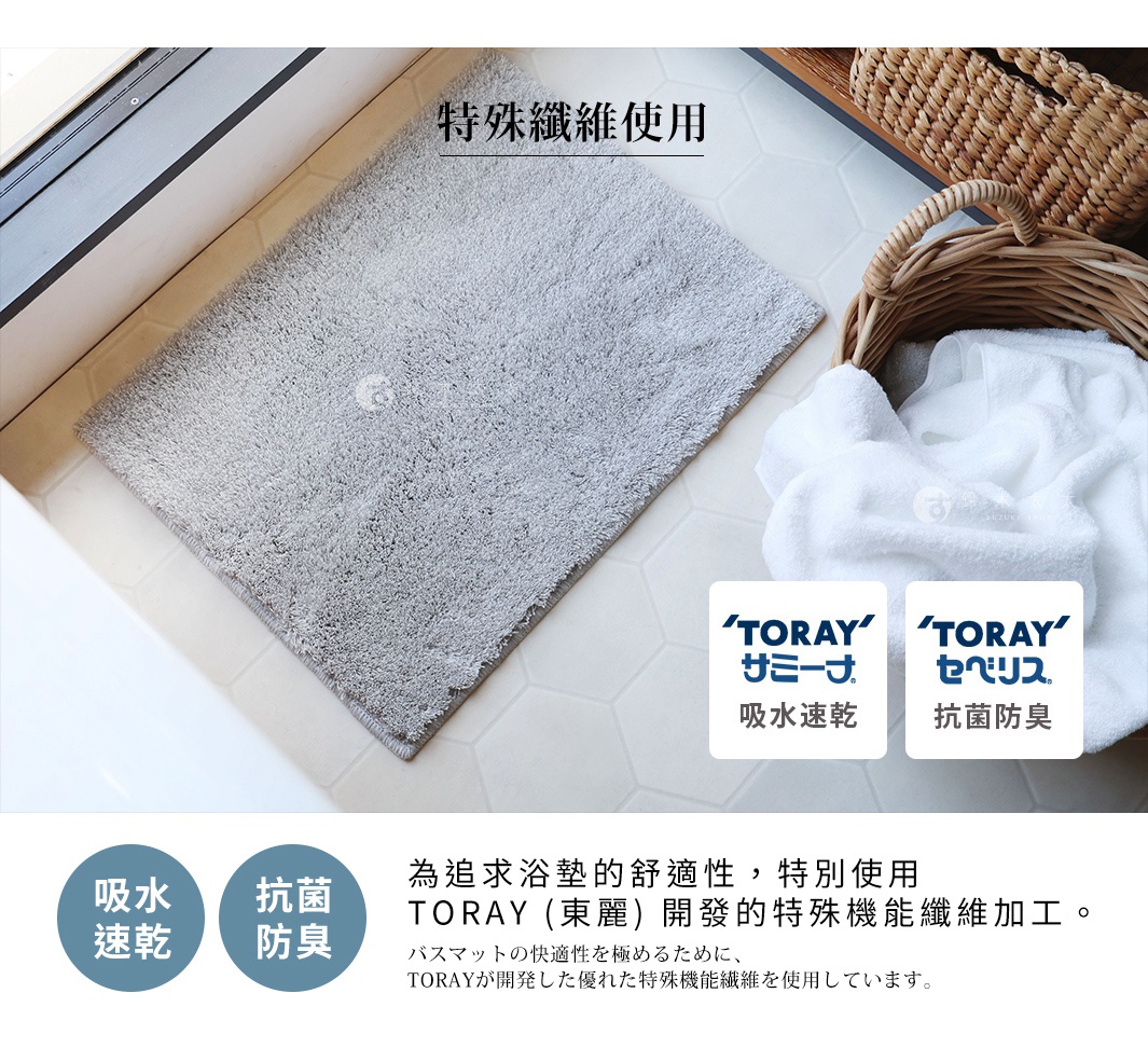 一個灰色毛絨浴墊鋪在白色六角形瓷磚上，左側是浴缸邊緣，右側有一個裝滿白色毛巾的柳條籃子，圖片下方有日文說明和圓形標籤，分別標示「吸水速乾」和「抗菌防臭」