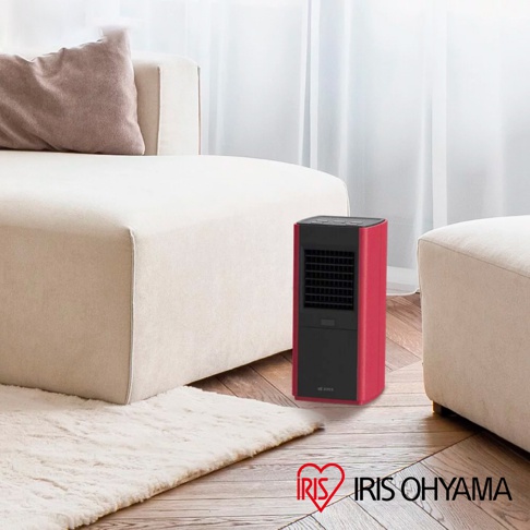 紅色與黑色直立式陶瓷電暖器，設有黑色格柵前面板，放置於米白色沙發旁的地板上。