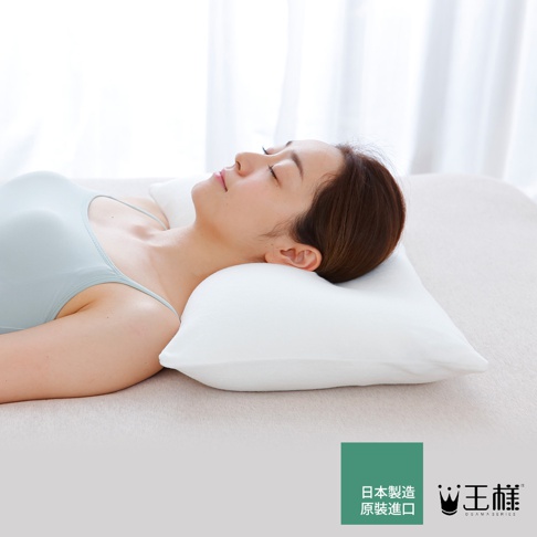 一位女性仰躺於白色枕頭上，枕頭呈現曲線設計，能服貼頸部，材質看似柔軟。