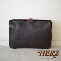 深棕色職人手作皮革Organ手拿包，簡約設計，帶有小巧的皮質搭扣，展現皮革自然紋理。