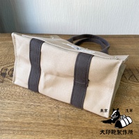 犬印純棉帆布迷你托特包，米白色帆布材質，搭配深灰色織帶裝飾及提把，包面印有黑白狗與行李袋圖案。