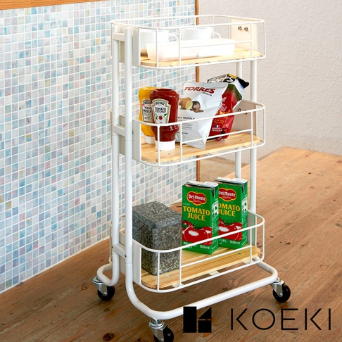 白色三層置物收納推車，架子為白色金屬網籃搭配淺木色層板，推車底部有四個萬向輪，推車上擺放著番茄醬、芥末醬、零食包、番茄汁盒和一個灰色長方體物品。