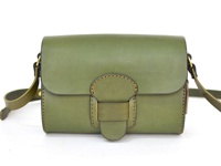 一綠色皮革馬鞍包，配有寬版可調式肩帶及金屬寬扣帶，包身縫線明顯，設計簡約。