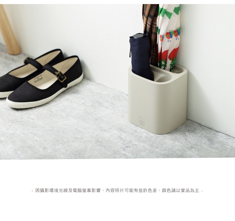 米色簡潔雨傘筒架，可收納摺疊傘及長柄傘，搭配黑色帆布平底鞋。