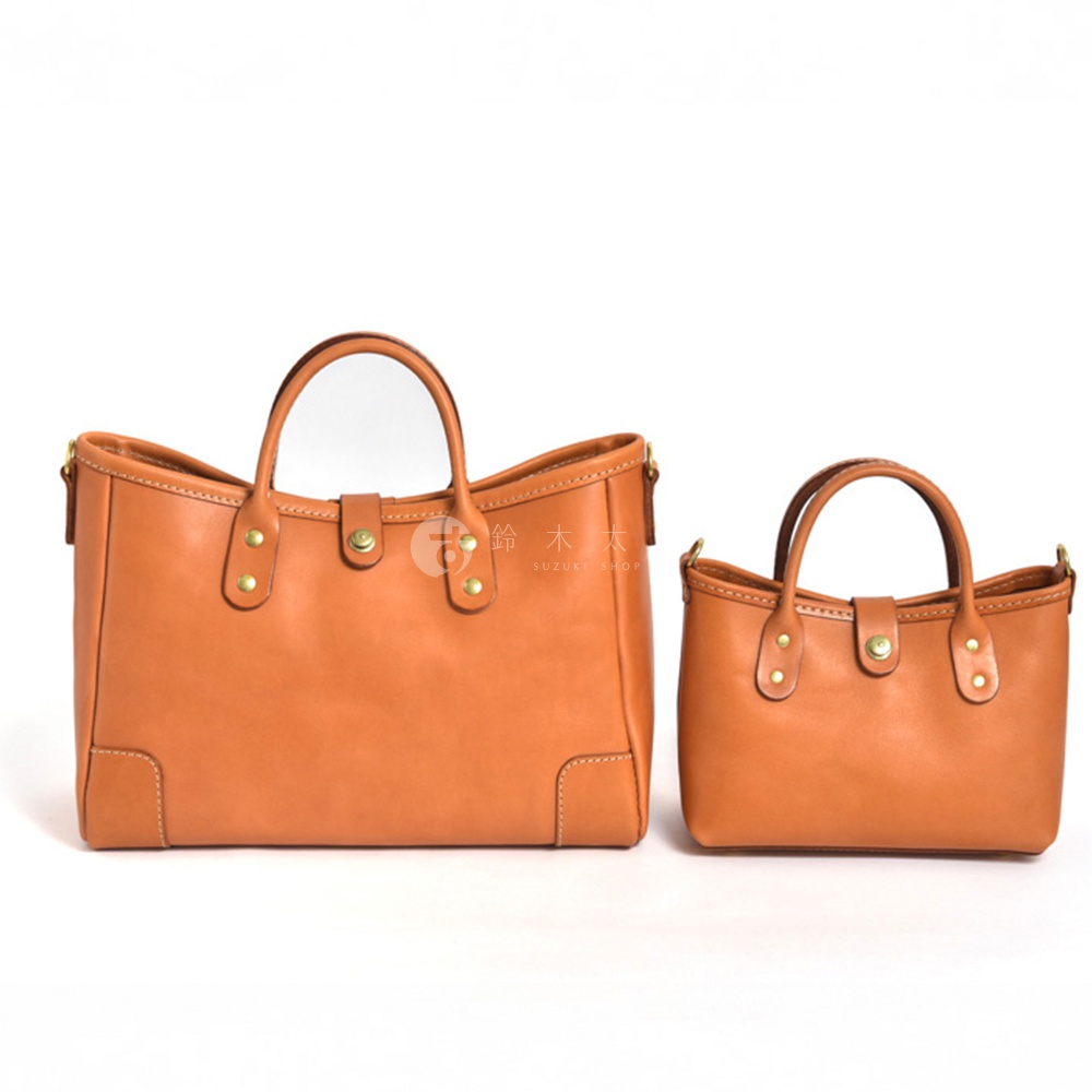 職人手作皮革迷你托特包 T-11，展示兩種尺寸。包款為天然棕色皮革材質，帶有簡潔的提把設計、金屬釦飾和精緻的車縫線，呈現經典復古風格。