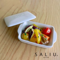 白色陶製萬用長方形烤盤，內含烤熟的茄子、黃甜椒、番茄等蔬菜，烤盤旁放有同色系的蓋子。