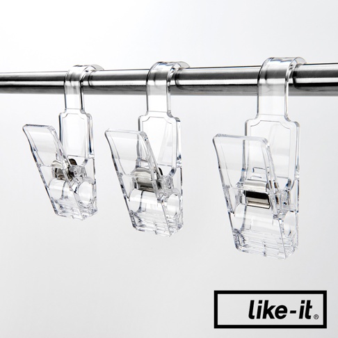 三個透明壓克力掛式小物夾，具有金屬彈簧，夾子開口朝下，掛在金屬桿上。