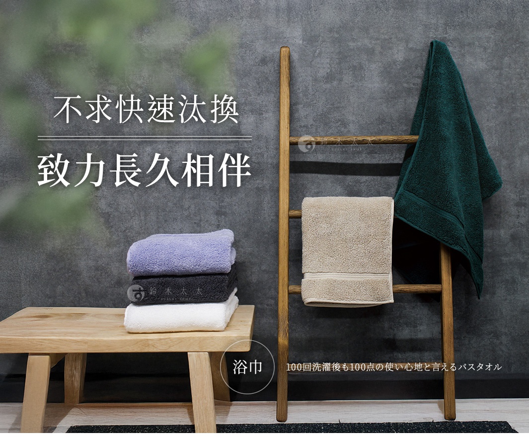 今治世紀傳承洗鍊輕盈浴巾，展示有深綠色、淺褐色、淺紫色、炭黑色和白色。部分浴巾堆疊在木凳上，另有兩條浴巾掛在木製梯架上，其中一條深綠色浴巾搭在頂端，一條淺褐色浴巾懸掛在中間。