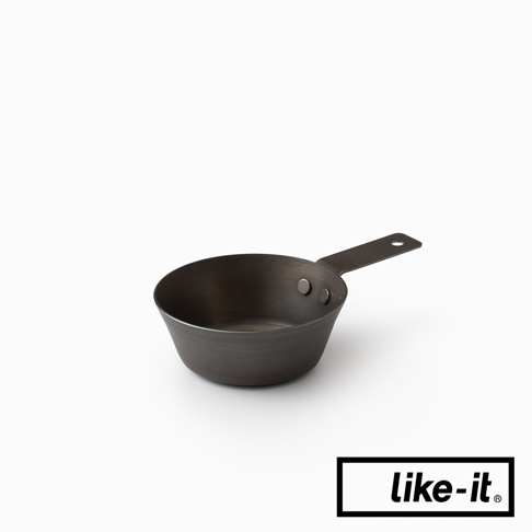 直火專用萬能調理把手鐵杯，材質為鐵，呈現深色金屬質感，杯身呈碗狀，連接單一長柄，柄上有一圓孔，杯身與柄以兩顆鉚釘固定。