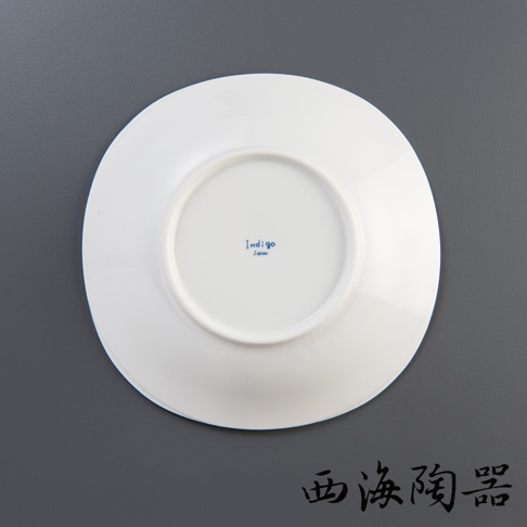 白色圓形陶瓷沙拉盤，盤底中央有藍色「Indigo Japan」字樣，盤緣有淺凹槽。