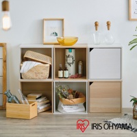 白色與木紋色立方體組合收納櫃，展示於牆面，櫃內擺放著編織籃、書籍、乾燥花束、精油瓶、裝飾瓶及畫框等物品。