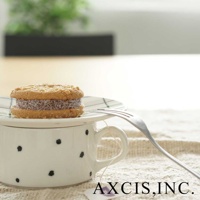 白色美濃燒手繪馬克杯，點綴黑色圓點，杯蓋上放著夾心餅乾，旁有一支叉子。