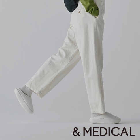&MEDICAL KAMOLEG 3.0 美腳健身機能鞋 M 的模特穿著米白色長褲和白色鞋子，擺出走路的姿勢。