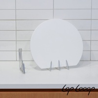 伸縮式不鏽鋼砧板架，銀色金屬材質，架上放置一個白色圓形砧板，背景為白色磁磚牆面。