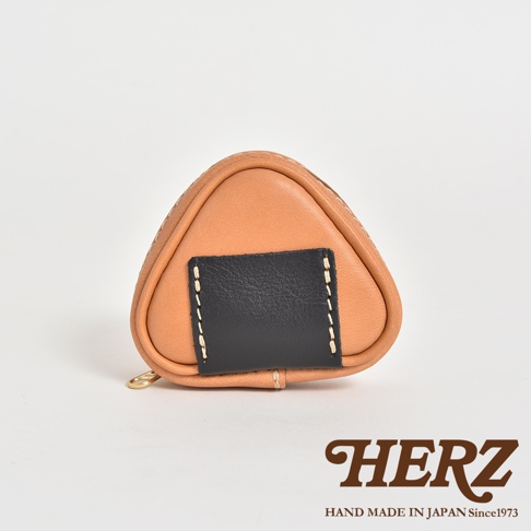 職人手作皮革三角飯糰造型小物收納包，以駱駝色皮革製成，搭配黑色皮革裝飾，縫線精緻，小巧實用。