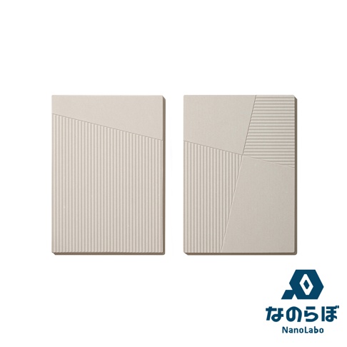 一組兩片淺米色珪藻土置物墊，表面呈現斜面拼接設計，其中一片有垂直細條紋，另一片則有垂直細條紋及斜線條紋。