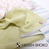 一條淺黃綠色今治純棉廚房擦拭巾，織有細緻紋理，邊緣有灰色滾邊。背景疊放著其他同系列擦拭巾，帶有橘色、藍色條紋。