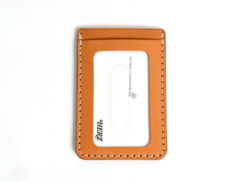 一個直式、淺棕色皮革票券收納夾，配有縫線和透明視窗，上面印有品牌標誌「HERZ」和英文文字。