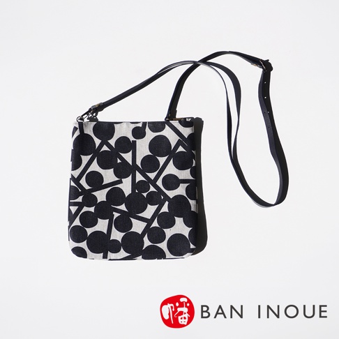 BAN INOUE 的自然織紋麻布斜背包，印有黑色果實花紋，搭配黑色皮質背帶。