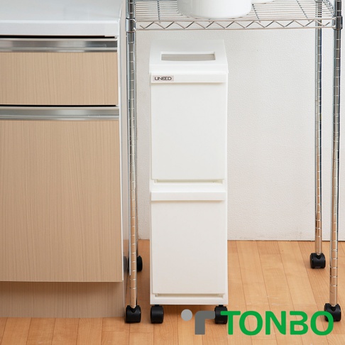 白色 UNEED 雙層抽屜式分類垃圾桶，帶有滑輪，置於廚房櫥櫃旁，垃圾桶上方有「UNEED」標誌。