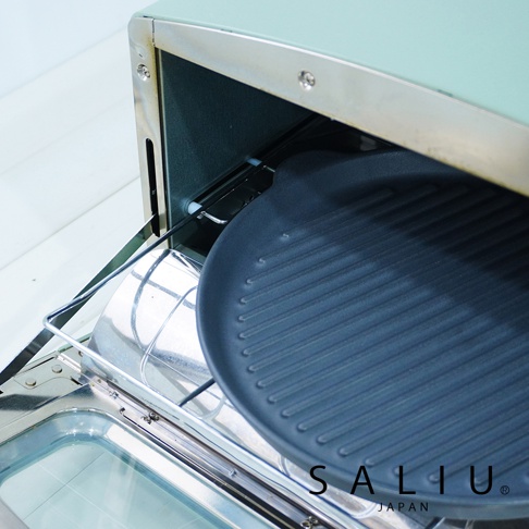 The chef 多功能耐熱陶製萬用波浪圓烤盤，內附一個深藍色、帶有明顯波浪紋路的圓形烤盤，置於烤箱烤架上。