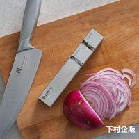 不鏽鋼磨刀器，印有 ESSYO 品牌標誌，旁邊有一把銀色不鏽鋼刀具和切片的紫洋蔥，放置於木質砧板上。