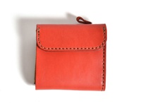 橘紅色皮革方形短夾，帶有縫線細節，左側有拉鍊，上方有一個皮革提帶。