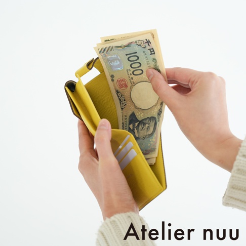 Atelier nuu 品牌字樣，以及黃色皮夾中放入日幣千元鈔票的特寫